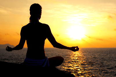 Calm person meditating with soft light, headphones optional