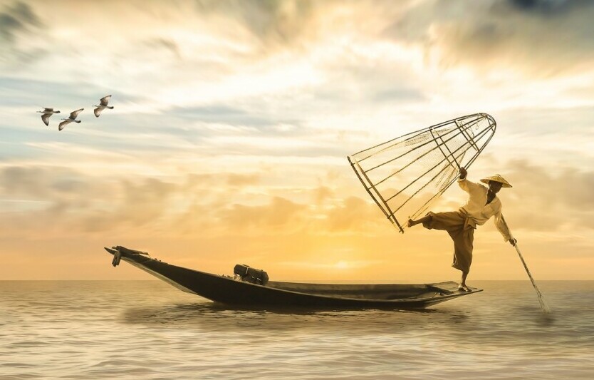 man balancing on the end of a boat representing balance and harmony in eastern thought